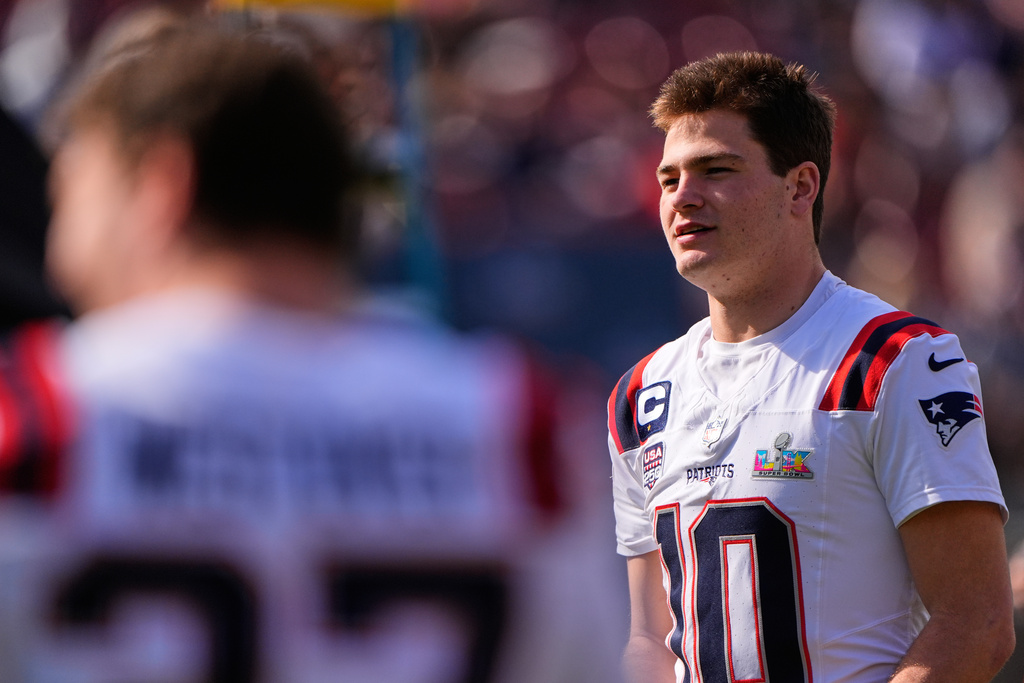 New England Patriots quarterback Drake Maye waits to be in a group photo at their practice venue for the Super Bowl 60 NFL football game against the Seattle Seahawks, Saturday, Feb. 7, 2026, in Stanford, Calif. (AP Photo/Charlie Riedel)
