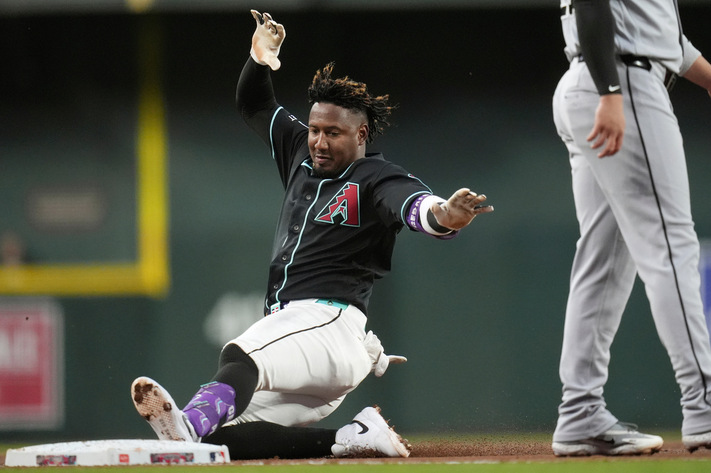 Arizona Diamondbacks' Geraldo Perdomo slides into third base with a triple against the Chicago White Sox during the first inning of a baseball game, Wednesday, April 22, 2026, in Phoenix. (AP Photo/Ross D. Franklin)