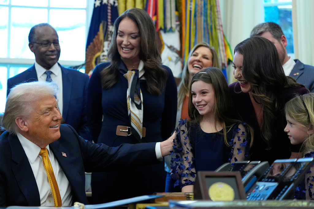 President Donald Trump talks to guests before he signs a bill that returns whole milk to school cafeterias across the country, in the Oval Office of the White House, Wednesday, Jan. 14, 2026, in Washington. (AP Photo/Alex Brandon)