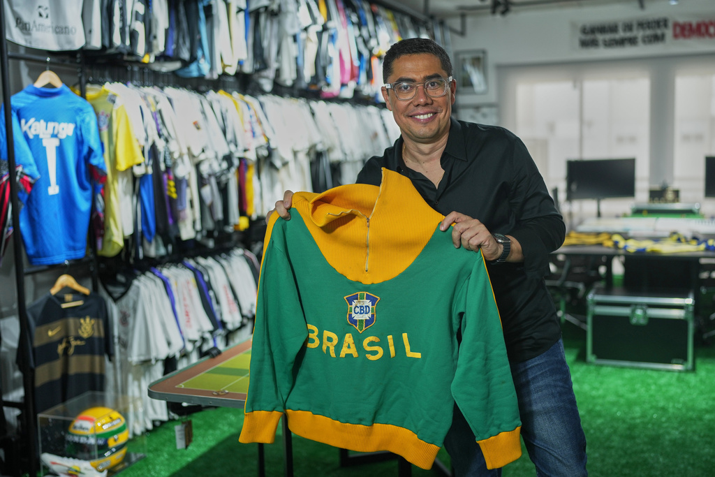 Cassio Brandao, owner of the Alambrado Futebol e Cultura store, poses for a photo with a jacket worn by late soccer legend Pele, also used by Bad Bunny during a concert a week prior, in Sao Paulo, Tuesday, Feb. 24, 2026. (AP Photo/Andre Penner)