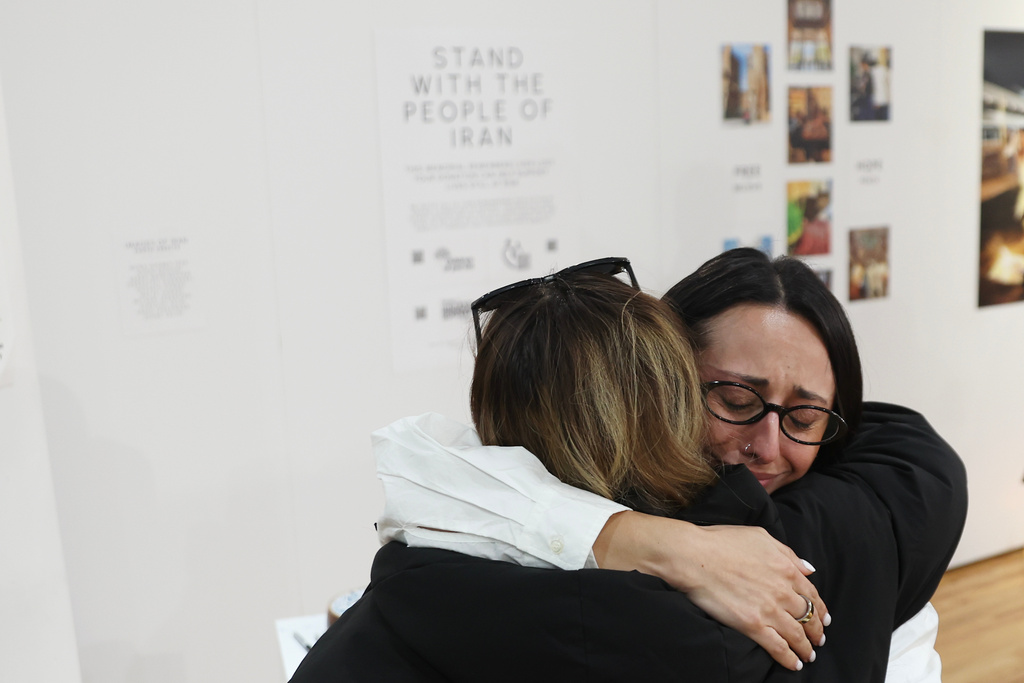 Forough Jafari hugs a visitor at a dedicated memorial space for the lives lost in Iran during a gathering in New York, on Saturday, March 14, 2026, for the upcoming Nowruz, Iranian/Persian New Year's day. (AP Photo/Heather Khalifa)