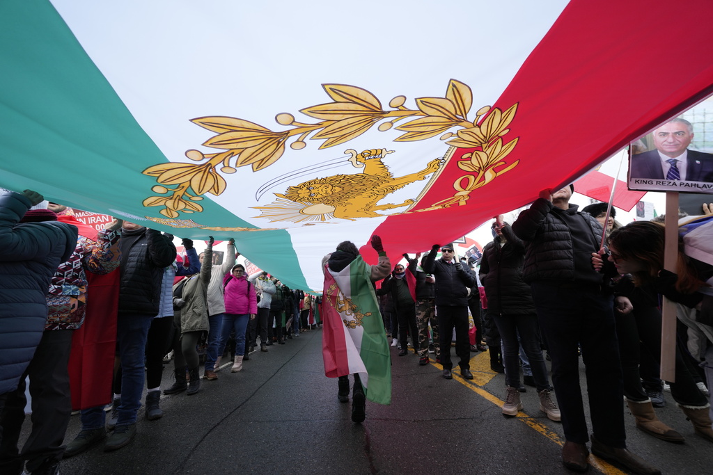 Carrying a huge lion and sun flag, supporters of Iran's exiled Crown Prince Reza Pahlavi attend a demonstration in Toronto, Saturday, Feb. 14, 2026. (AP Photo/Kamran Jebreili)