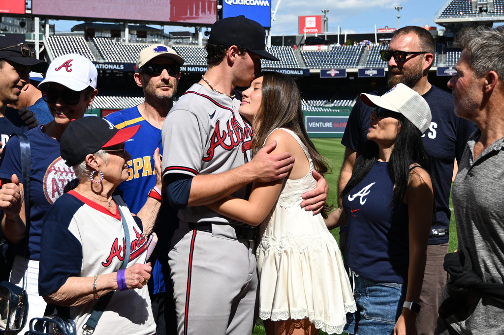 Atlanta Braves starting pitcher JR Ritchie, left center, hugs his fiancée Makena Miller after winning his major league debut baseball game against the Washington Nationals, Thursday, April 23, 2026, in Washington. (AP Photo/Nick Wass)