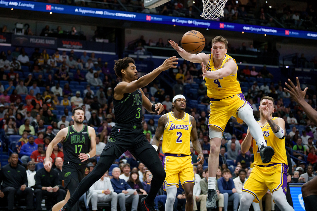 New Orleans Pelicans guard Jordan Poole (3) passes around Los Angeles Lakers forward Dalton Knecht (4) during the first half of an NBA basketball game in New Orleans, Tuesday, Jan. 6, 2026. (AP Photo/Matthew Hinton)
