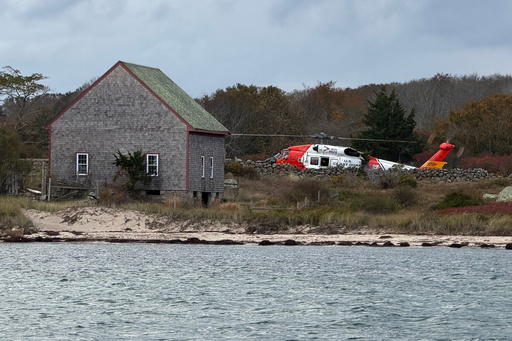 A U.S. Coast Guard helicopter approaches Naushon Island, Mass. Wednesday, Oct. 22, 2025, where a couple and their adult son were rescued two days after their boat caught fire and they swam to shore. (U.S. Coast Guard via AP) A U.S. Coast Guard helicopter approaches Naushon Island, Mass. Wednesday, Oct. 22, 2025, where a couple and their adult son were rescued two days after their boat caught fire and they swam to shore. (U.S. Coast Guard via AP)