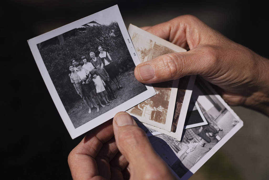 A family photo of Marion Vinetta Nagle McWhorter, back center in white, who disappeared in 1974 in Oregon, and whose remains were recently identified, is held by her sister Valerie Nagle Thursday, Sept. 18, 2025, in Seattle. (AP Photo/Lindsey Wasson)