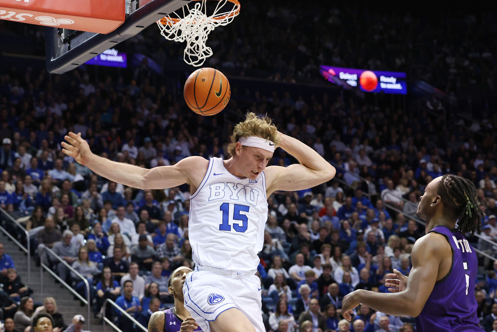 BYU guard Richie Saunders (15) dunks on Abilene Christian guard Cbo Newton during the second half of an NCAA college basketball game Friday, Dec. 19, 2025, in Provo, Utah. (AP Photo/Jeffrey D. Allred)