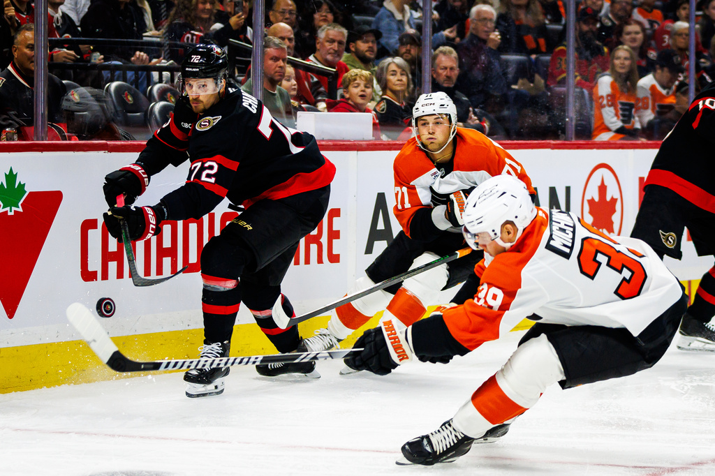Ottawa Senators' Thomas Chabot (72) clears the puck while under pressure from Philadelphia Flyers' Tyson Foerster (71) and Matvei Michkov (39) during the first period of an NHL hockey game in Ottawa, Ontario, Thursday, Oct. 8, 2026. (Keito Newman/The Canadian Press via AP)
