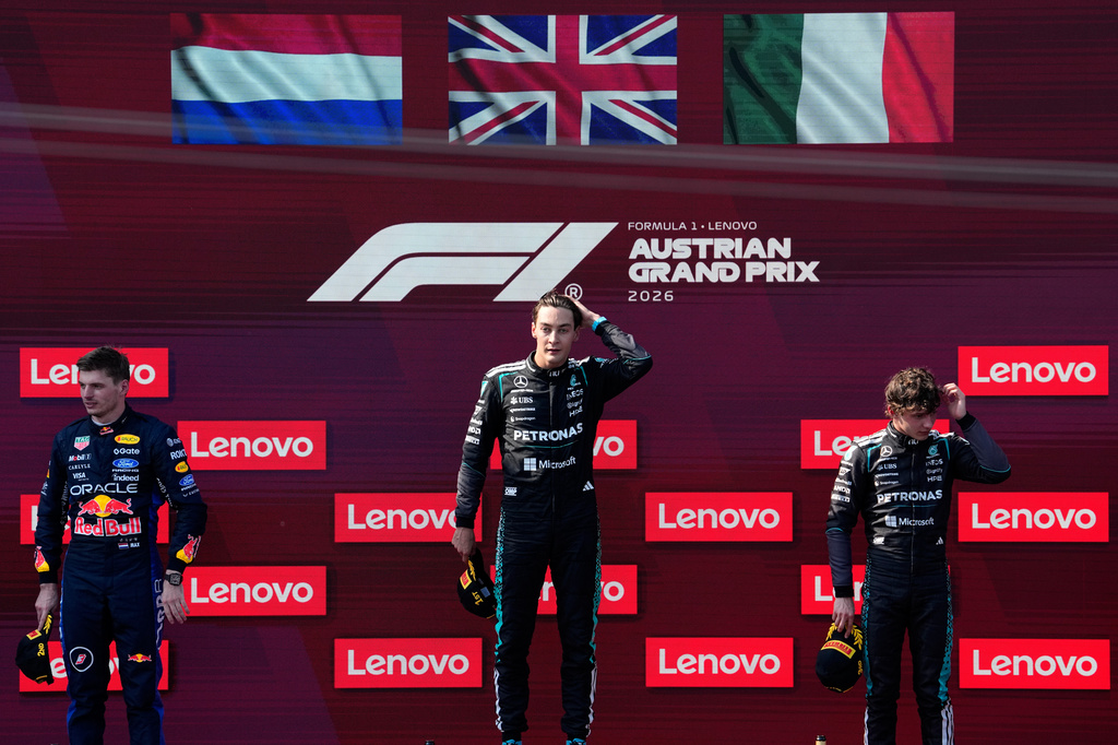 Race winner Mercedes driver George Russell of Britain, center, stands on the podium with second placed Red Bull driver Max Verstappen of the Netherlands, left, and third placed Mercedes driver Andrea Kimi Antonelli of Italy after the Austrian F1 Grand Prix, in Spielberg, Austria, Sunday, June 28, 2026. (AP Photo/Darko Bandic)