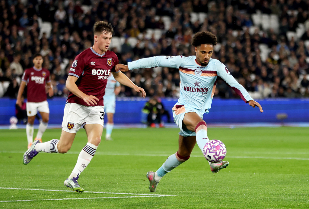 West Ham United's Oliver Scarles, left, and Brentford's Kevin Schade battle for the ball during the English Premier League soccer match between West Ham United and Brentford at the London Stadium, London, Monday Oct. 20, 2025. (Steven Paston/PA via AP)