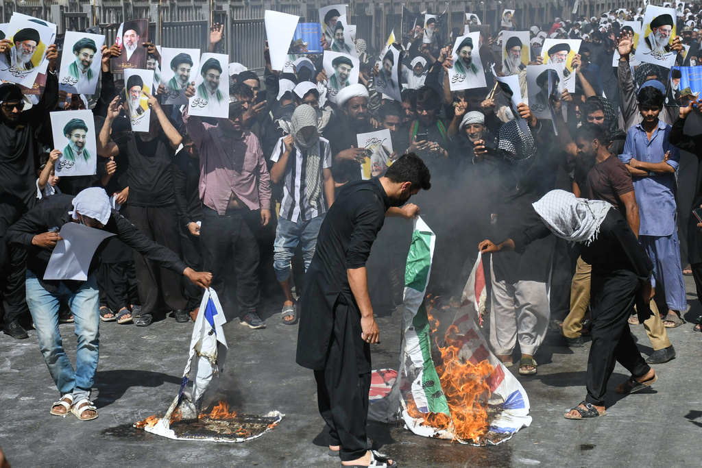 Shiite Muslims burn representation of U.S. Indian and Israeli flags during a procession, in Karachi, Pakistan, Wednesday, March 11, 2026. (AP Photo/Ali Raza)