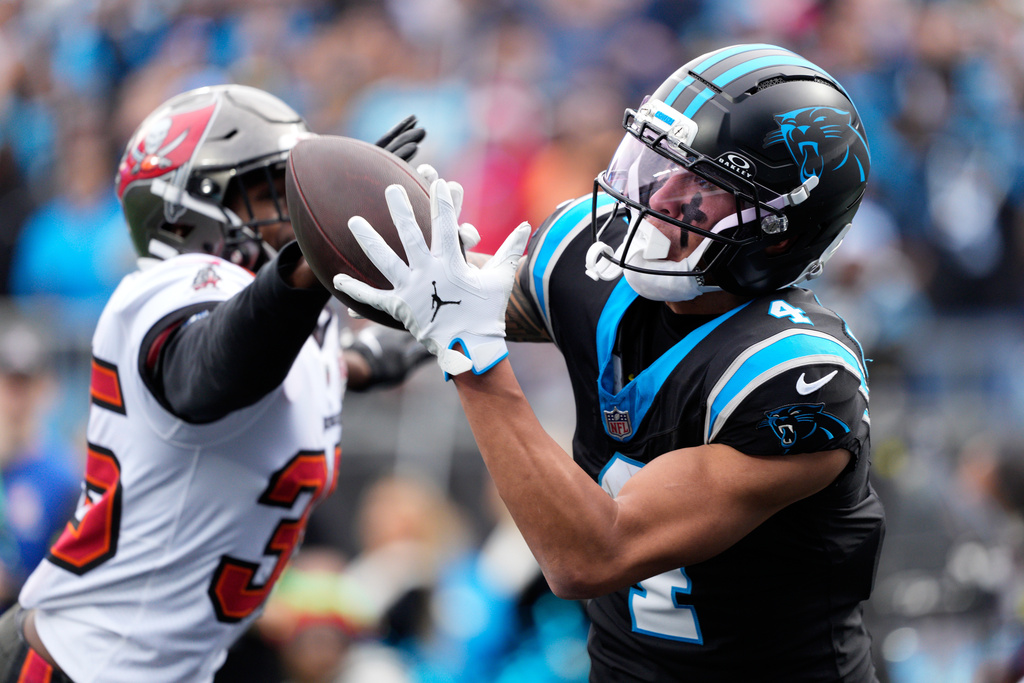 Carolina Panthers wide receiver Tetairoa McMillan catches a touchdown pass ahead of Tampa Bay Buccaneers cornerback Jamel Dean during the first half of an NFL football game, Sunday, Dec. 21, 2025, in Charlotte, N.C. (AP Photo/Jacob Kupferman)