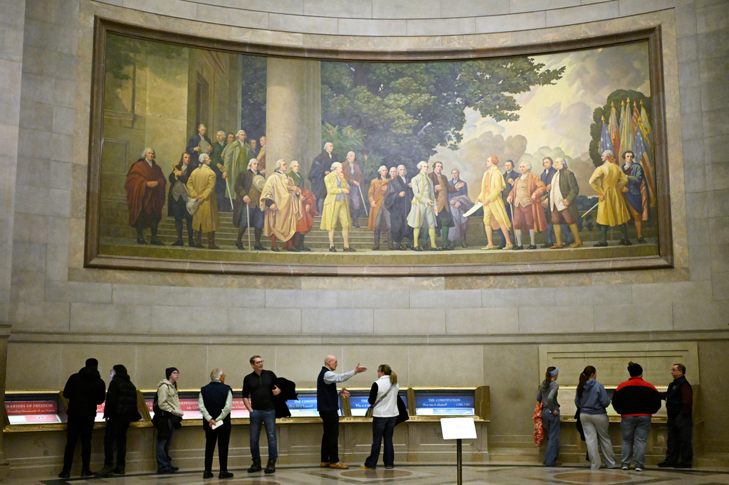 FILE - A large wall mural showing the signing of the Declaration of Independence is seen over visitors at the National Archives, Jan. 29, 2026, in Washington. (AP Photo/John McDonnell, File)