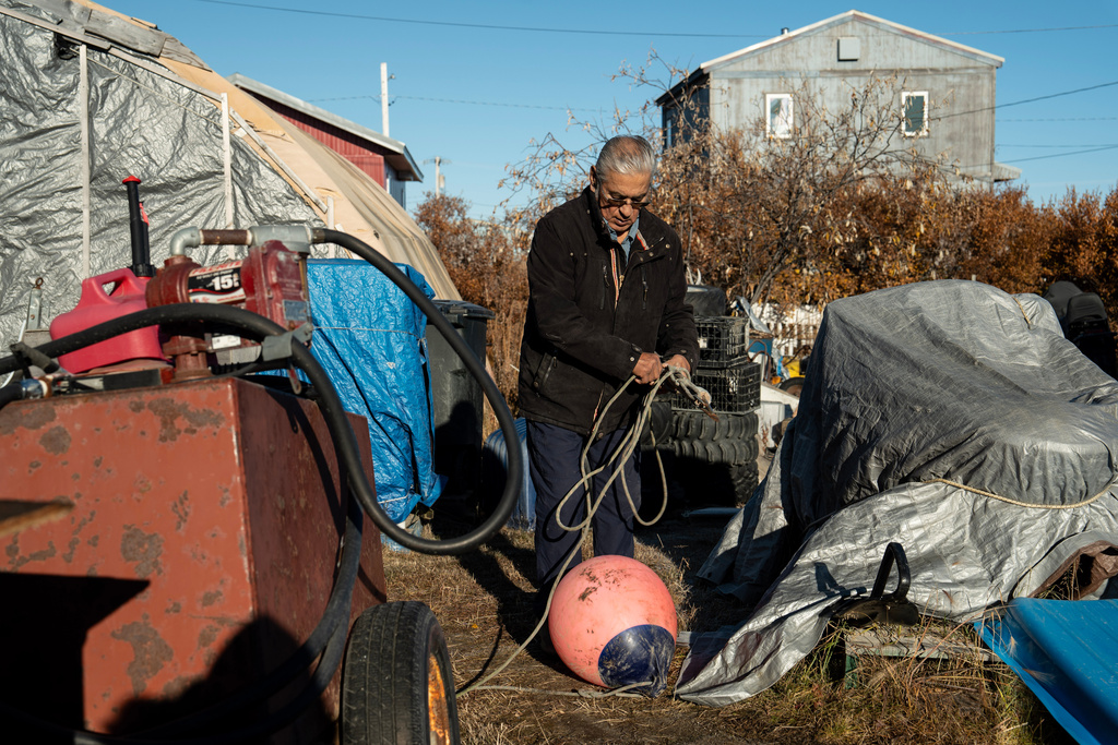 Roswell Schaeffer, an Inupiaq hunter and fisher, organizes hunting equipment next to his covered snowmobile outside his home in Kotzebue, Alaska, Friday, Sept. 26, 2025. (AP Photo/Annika Hammerschlag)