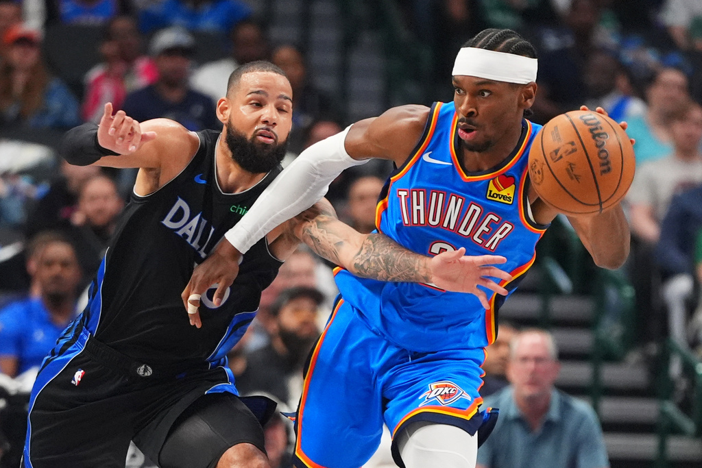 Oklahoma City Thunder guard Shai Gilgeous-Alexander, right, keeps the ball from a reaching Dallas Mavericks forward Caleb Martin Shai Gilgeous-Alexander during the first half of an NBA basketball game in Dallas, Sunday, March 1, 2026. (AP Photo/LM Otero)
