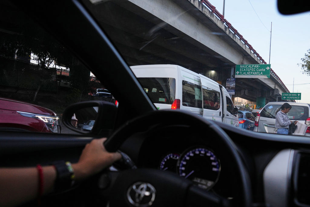 Diana Guzman, a driver with AmorrAs, a feminist transportation collective that offers rides to women who prefer alternatives to public transit due to safety concerns, drives a passenger home in the State of Mexico, Thursday, Nov. 6, 2025. (AP Photo/Claudia Rosel)