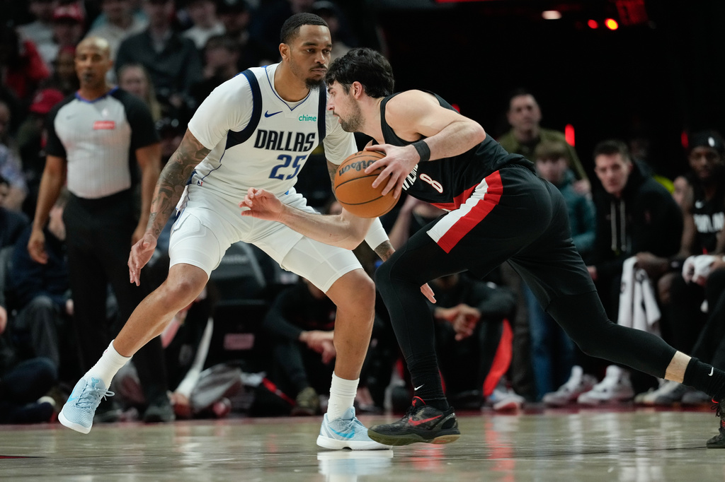 Portland Trail Blazers forward Deni Avdija (8) drives to the basket past Dallas Mavericks forward P.J. Washington (25) during the first half of an NBA basketball game Friday, March 27, 2026, in Portland, Ore. (AP Photo/Jenny Kane)