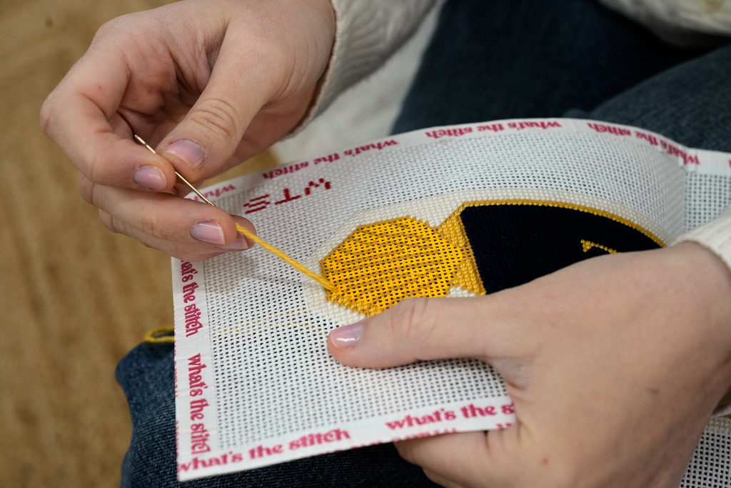 Emma MacTaggart, founder of What's the Stitch needlepoint business, works on a needlepoint in her studio, in New York, Monday, Feb. 9, 2026. (AP Photo/Richard Drew)
