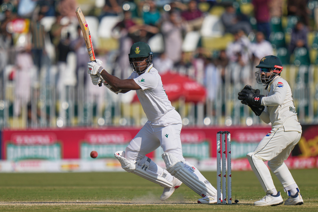 South Africa's Kagiso Rabada, left, plays a shot as Pakistan's Mohammad Rizwan watches during the third day of the second test cricket match between Pakistan and South Africa, in Rawalpindi, Pakistan, Wednesday, Oct. 22, 2025. (AP Photo/Anjum Naveed)