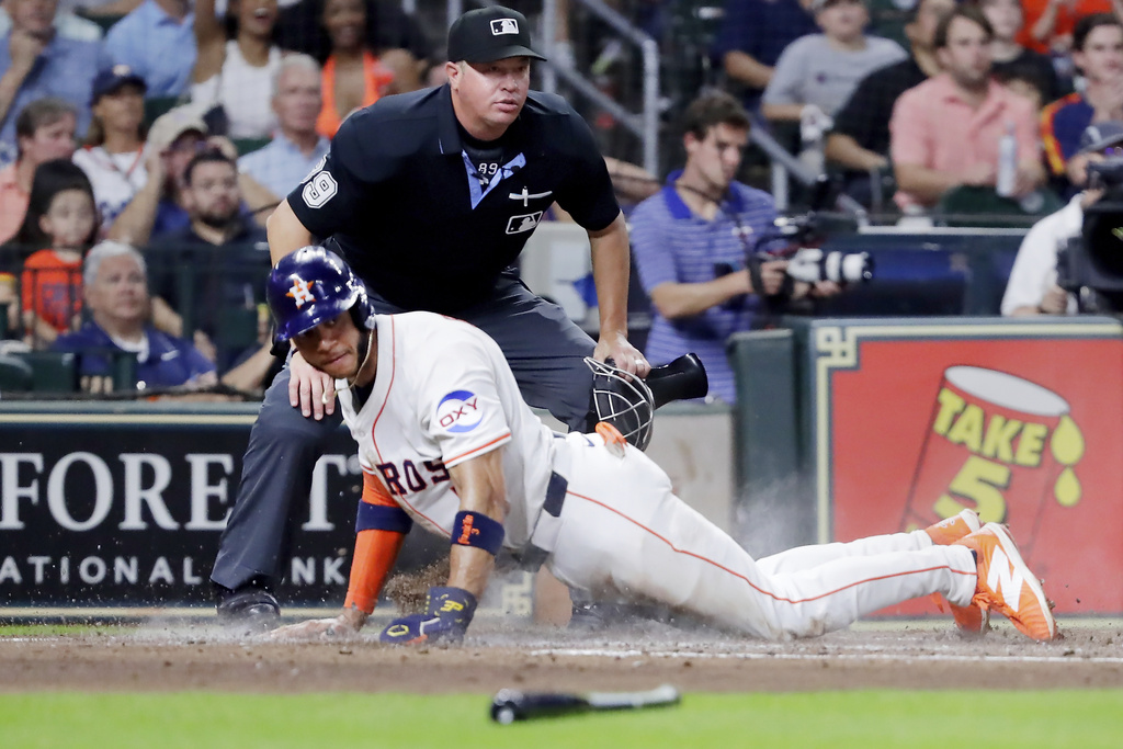 Houston Astros' Jeremy Pena scores his second run in front of umpire Cory Blaser, top, against the Texas Rangers during the third inning of a baseball game Tuesday, Sept. 16, 2025, in Houston. (AP Photo/Michael Wyke)