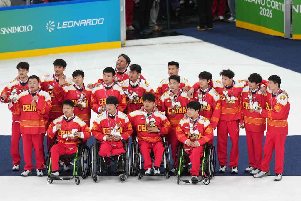 China's players celebrate after taking a bronze medal during the ice hockey bronze medal match between China and Czechia at the 2026 Winter Paralympics, in Milan, Italy, Sunday, March 15, 2026. (AP Photo/Antonio Calanni)