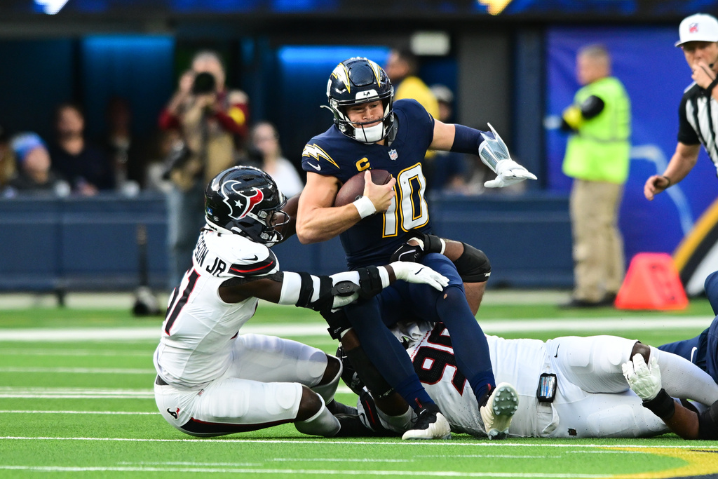 Los Angeles Chargers quarterback Justin Herbert (10) is sacked by Houston Texans defensive end Will Anderson Jr. (51) during the first half of an NFL football game Saturday, Dec. 27, 2025, in Inglewood, Calif. (AP Photo/Wally Skalij)