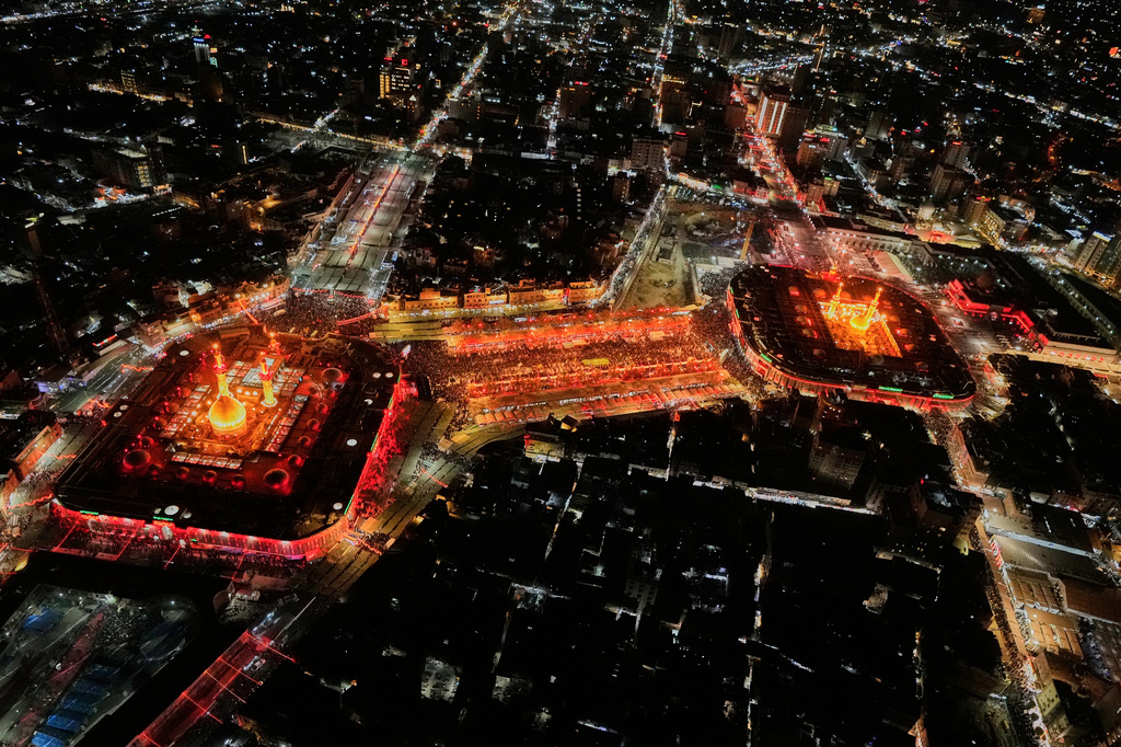 Aerial photo shows Shiite pilgrims gathering between the illuminated holy shrine of Imam Hussein and the holy shrine of Imam Abbas, ahead for Arbaeen, the annual Shiite commemoration marking 40 days after Ashura, in Karbala, Iraq, late Sunday, Aug. 2, 2026. (AP Photo/Hadi Mizban)