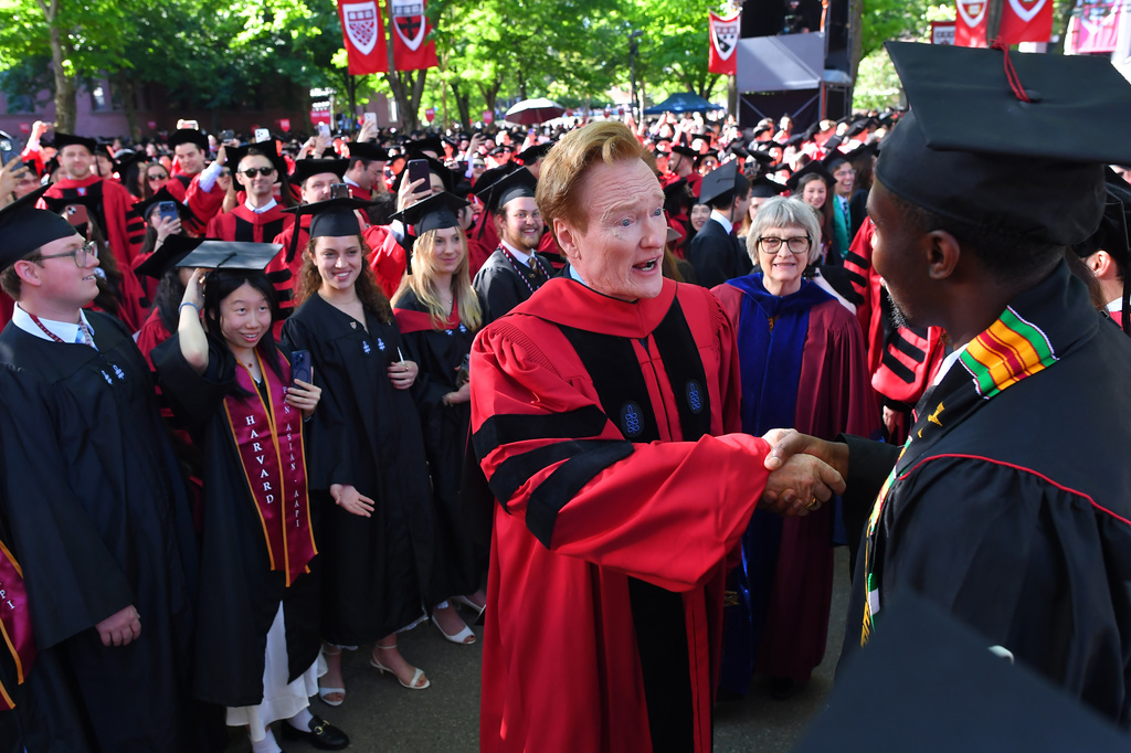 Comedian Conan O'Brien, center, greets people while walking in a procession through Harvard Yard, before delivering a commencement address during Harvard University commencement exercises on the school's campus, Thursday, May 28, 2026, in Cambridge, Mass. (AP Photo/Steven Senne)