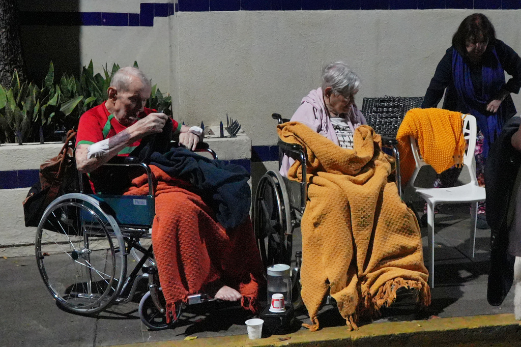 Seniors sit outside damaged buildings after an earthquake in Caracas, Venezuela, Wednesday, June 24, 2026. (AP Photo/Adrian Naranjo)