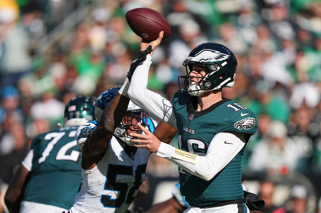 Philadelphia Eagles quarterback Tanner McKee, right, attempts a pass under pressure from Carolina Panthers inside linebacker Bobby Okereke (58) during the second half of an NFL football game in Philadelphia, Sunday, Oct. 18, 2026. (AP Photo/Matt Rourke)