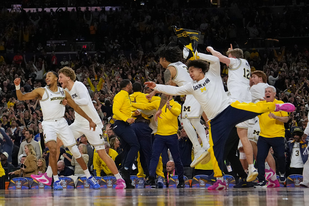 Members of Michigan celebrate after defeating UConn in the NCAA college basketball tournament national championship game at the Final Four, Monday, April 6, 2026, in Indianapolis. (AP Photo/Michael Conroy)