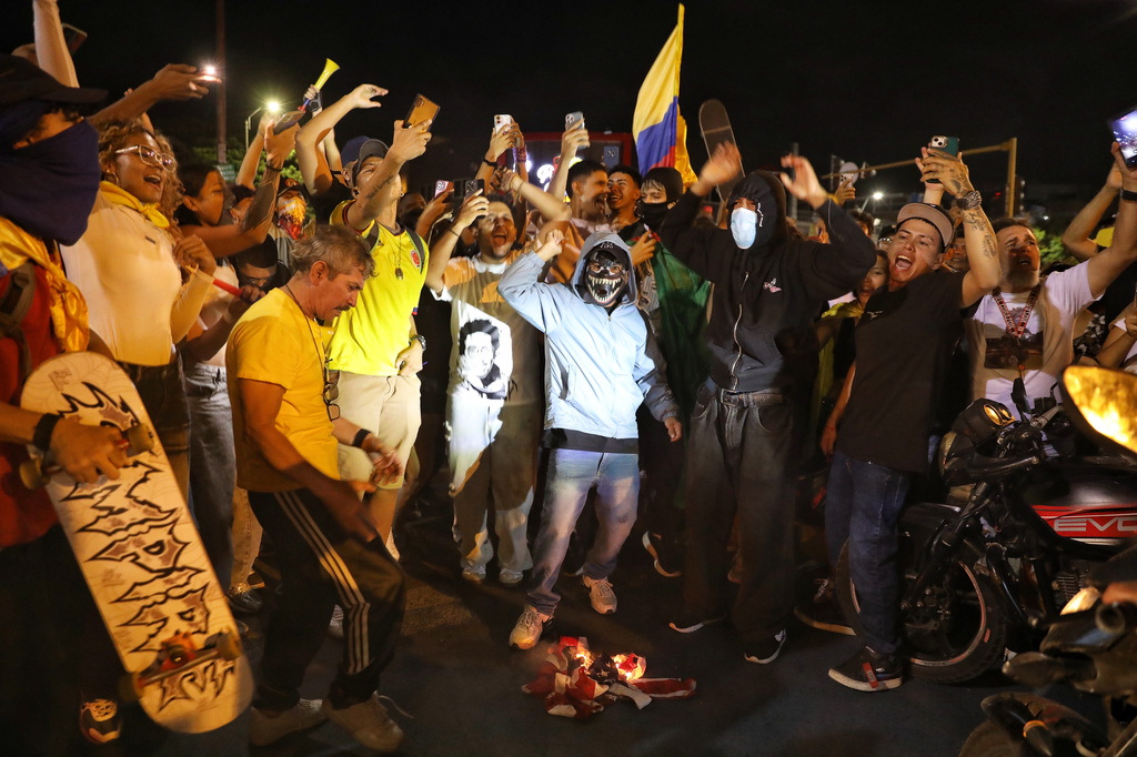 Supporters of presidential candidate Ivan Cepeda of the ruling Historic Pact coalition burn a U.S. flag after election results showed him trailing in the runoff election in Cali, Colombia, Sunday, June 21, 2026. (AP Photo/Santiago Saldarriaga)