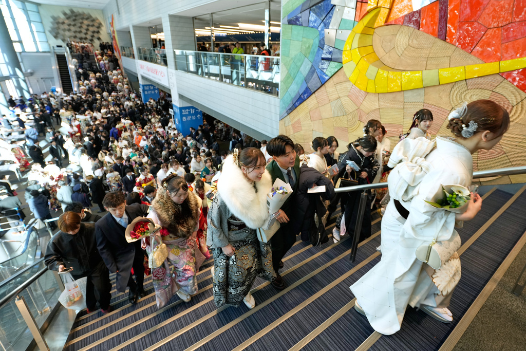 Young adults arrive at a venue to celebrate the Coming-of-Age Day, a centuries-old tradition and national holiday marking the milestone from childhood to adulthood, Monday, Jan. 12, 2026, in Yokohama near Tokyo. (AP Photo/Eugene Hoshiko)