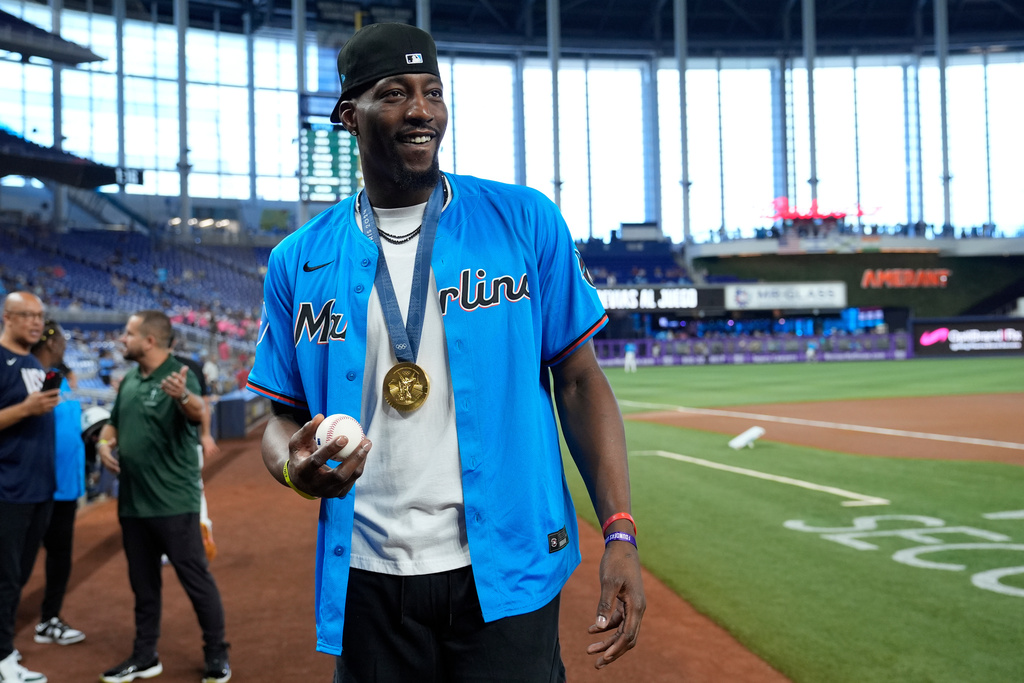 FILE - Miami Heat forward Bam Adebayo, wearing his Olympic gold medal, stands on the field before throwing a ceremonial pitch at a baseball game between the Miami Marlins and the Chicago Cubs, Sunday, Aug. 25, 2024, in Miami. (AP Photo/Lynne Sladky, file)