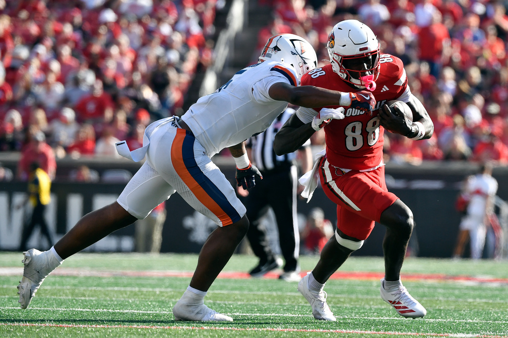 Virginia linebacker Kam Robinson (5) makes a hit on Louisville Cardinals tight end Jaleel Skinner (88) during the first half of an NCAA college football game in Louisville, Ky., Saturday, Oct. 4, 2025. (AP Photo/Timothy D. Easley)