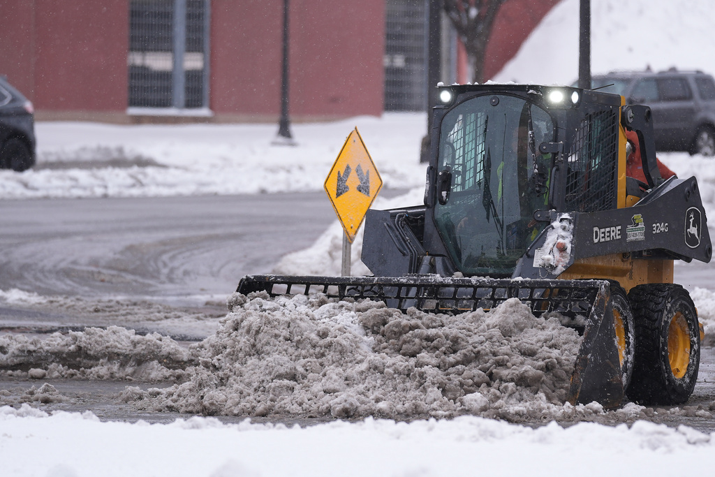 A snow plow clears snow Sunday, March 15, 2026, in St. Paul, Minn. (AP Photo/Abbie Parr)
