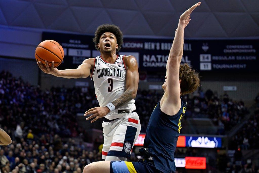 UConn forward Jaylin Stewart (3) goes up to shoot as Marquette forward Ben Gold, right, defends in the first half of an NCAA college basketball game, Sunday, Jan. 4, 2026, in Storrs, Conn. (AP Photo/Jessica Hill)
