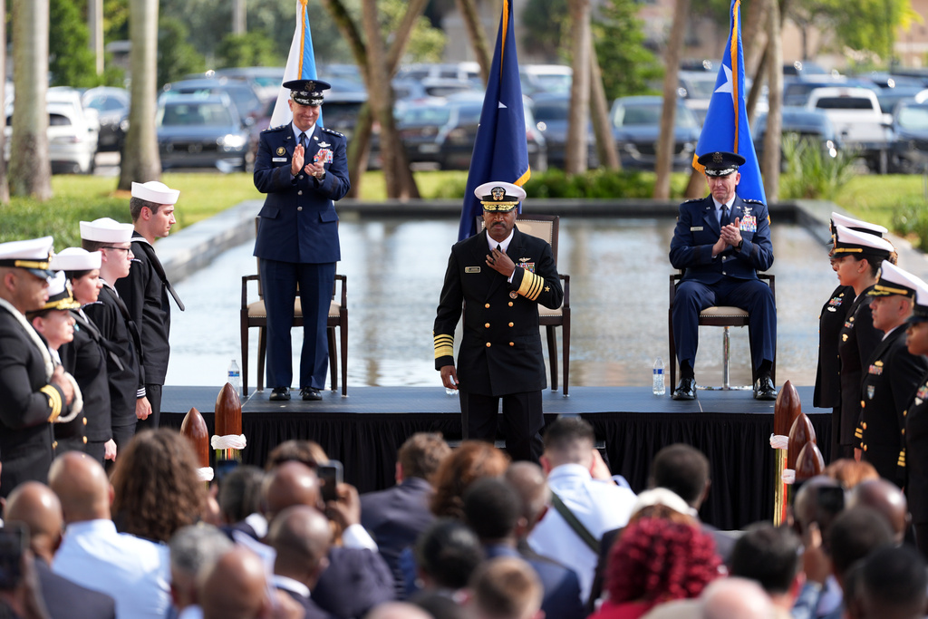 Navy Adm. Alvin Holsey, center, leaves the stage as Gen. Dan Caine, left, chairman of the Joint Chiefs of Staff, and Air Force Lt. Gen. Evan Pettus, taking over command, applaud during Holsey's relinquishment of command and retirement ceremony, at U.S. Southern Command, Friday, Dec. 12, 2025, in Doral, Fla. (AP Photo/Rebecca Blackwell)