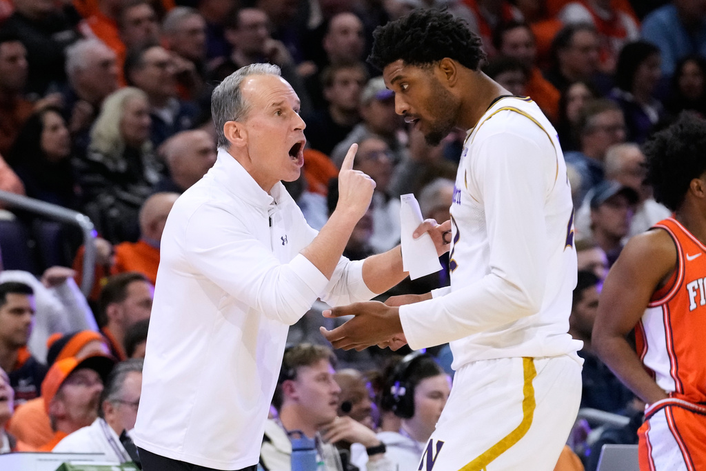 Northwestern head coach Chris Collins, left, talks to forward Arrinten Page during the first half of an NCAA college basketball game against Illinois in Evanston, Ill., Wednesday, Jan. 14, 2026. (AP Photo/Nam Y. Huh)