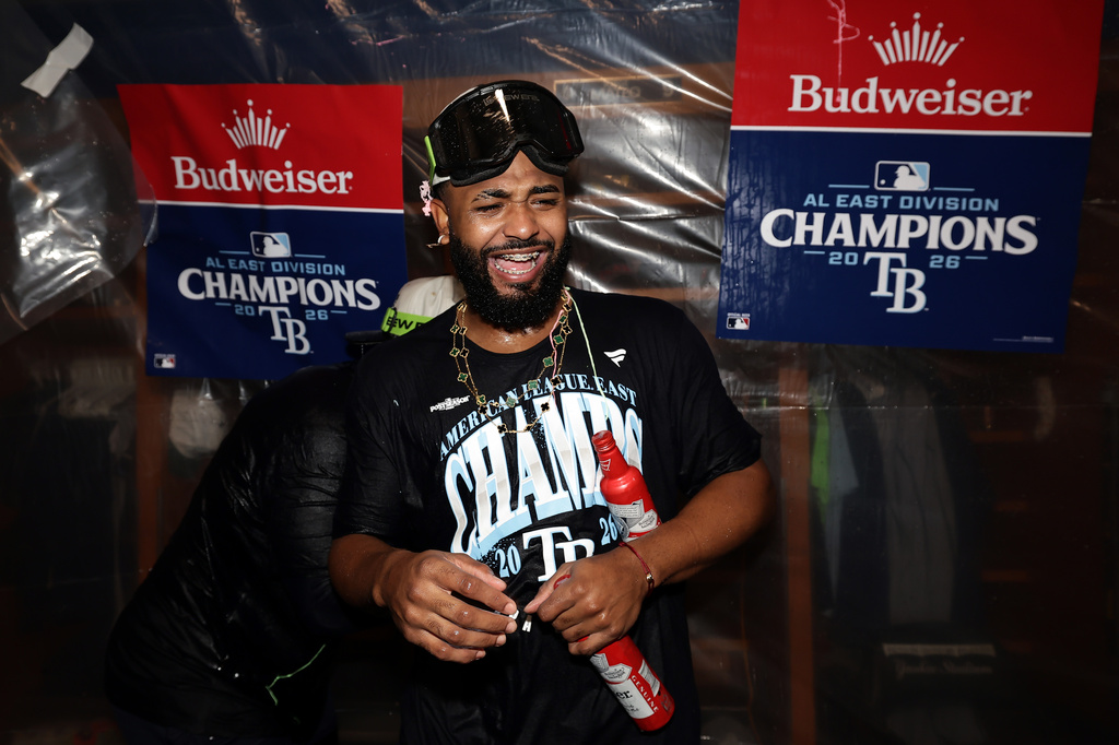 Tampa Bay Rays third baseman Junior Caminero celebrates in the locker room after the Rays defeated the New York Yankees to win the AL East Division after the second baseball game of a doubleheader Tuesday, Sept. 22, 2026, in New York. (AP Photo/Adam Hunger)
