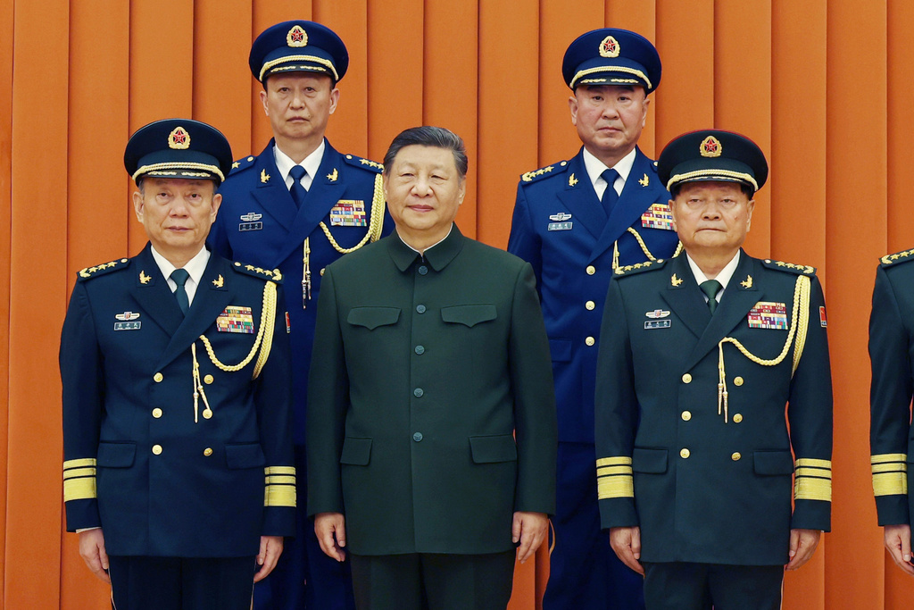 In this photo released by Xinhua News Agency, Chinese President Xi Jinping, also chairman of the Central Military Commission (CMC), front row second from left, poses with other military officers after promoting to generals, back row, from left, Yang Zhibin of the Eastern Theater Command and Han Shengyan commander of Central Theater Command in Beijing on Monday, Dec. 22, 2025. (Li Gang/Xinhua via AP)