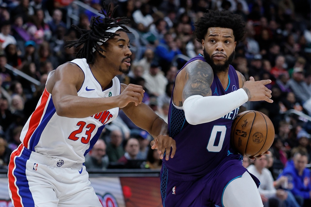 Charlotte Hornets forward Miles Bridges (0) drives against Detroit Pistons guard Jaden Ivey (23) during the first half of an NBA basketball game, Saturday, Dec. 20, 2025, in Detroit. (AP Photo/Duane Burleson)