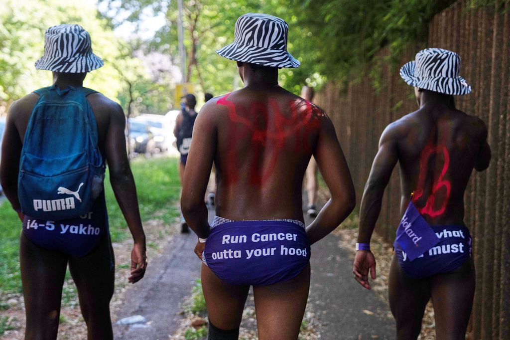 Men walk through the streets wearing only purple swim briefs to raise awareness about prostate cancer, in Johannesburg, Friday, Oct. 23, 2026. (AP Photo)
