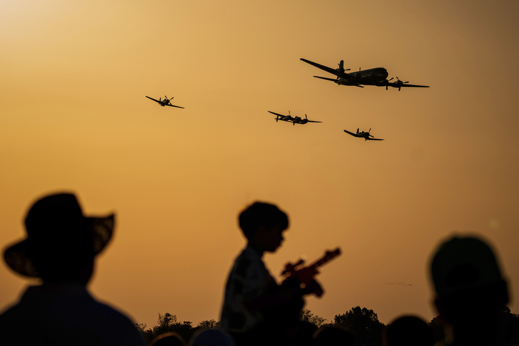 A Douglas DC-6B plane leads the Flying Bulls Red Bull aerobatic team above the runway of the Aurel Vlaicu airport, on the first day of the Bucharest International Air Show, BIAS 2025 in Bucharest, Romania, Saturday, Aug. 30, 2025. (AP Photo/Andreea Alexandru)