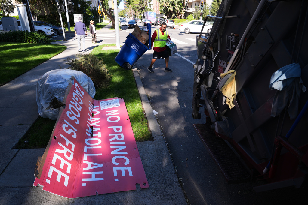 Signs from a Sunday protest, supporting protesters in Iran, are left on a sidewalk Monday, Jan. 12, 2026, in Los Angeles. (AP Photo/Damian Dovarganes)