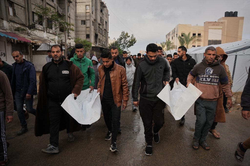 Mourners carry the bodies of Palestinians killed in an Israeli military strike, at Nasser Hospital in Khan Younis, Gaza Strip, Friday, Jan. 9, 2026. (AP Photo/Abdel Kareem Hana)