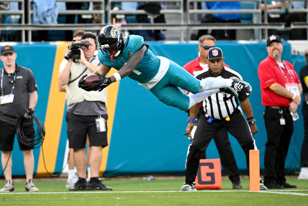 Jacksonville Jaguars running back Travis Etienne Jr. (1) scores a touchdown against the New York Jets during the second half of an NFL football game, Sunday, Dec. 14, 2025, in Jacksonville, Fla. (AP Photo/Phelan M. Ebenhack)