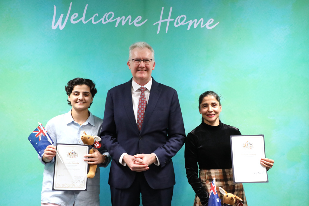 Fatemeh Pasandideh, left, and Atefeh Ramezanisadeh, former members of the Iranian women’s soccer team, stand with Australia's Minister for Home Affairs, Tony Burke, after receiving their citizenship in Brisbane, Australia, Wednesday, Aug. 5, 2026. (Department of Home Affairs via AP)