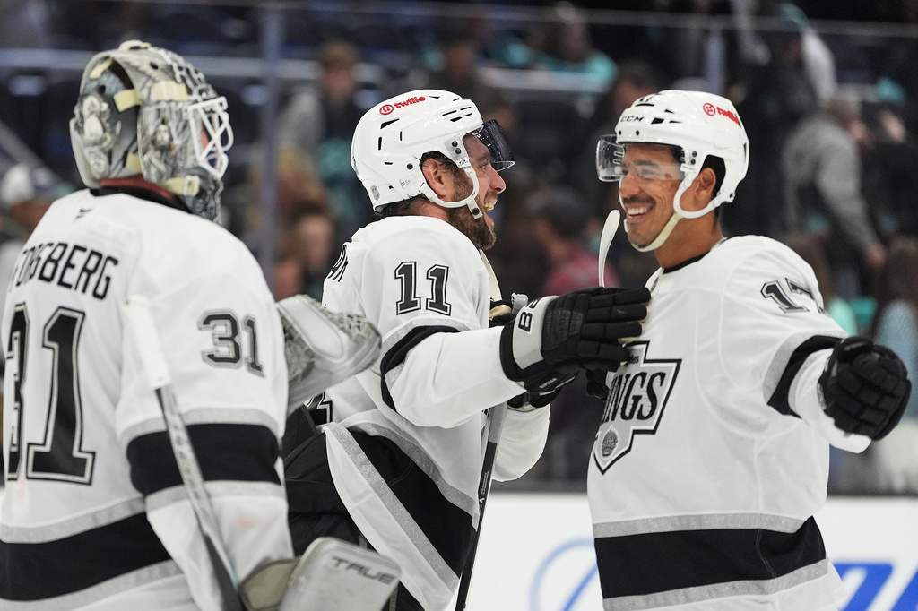 Los Angeles Kings goaltender Anton Forsberg (31), center Anze Kopitar (11) and right wing Mathieu Joseph (17) celebrate a win over the Seattle Kraken in an NHL hockey game Monday, April 13, 2026, in Seattle. (AP Photo/Lindsey Wasson)