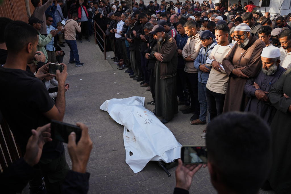 Mourners pray over the body of Ruba Abu Al-Ola, 22, killed in an Israeli army strike, during her funeral at Nasser Hospital in Khan Younis, Gaza Strip Thursday, Nov. 20, 2025. (AP Photo/Abdel Kareem Hana)